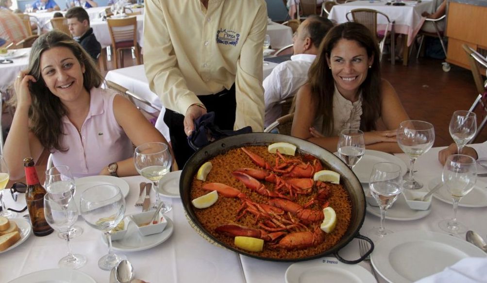 file-photo-of-a-waiter-serving-a-traditional-paella-at-a-beach-side-restaurant-in-valencia